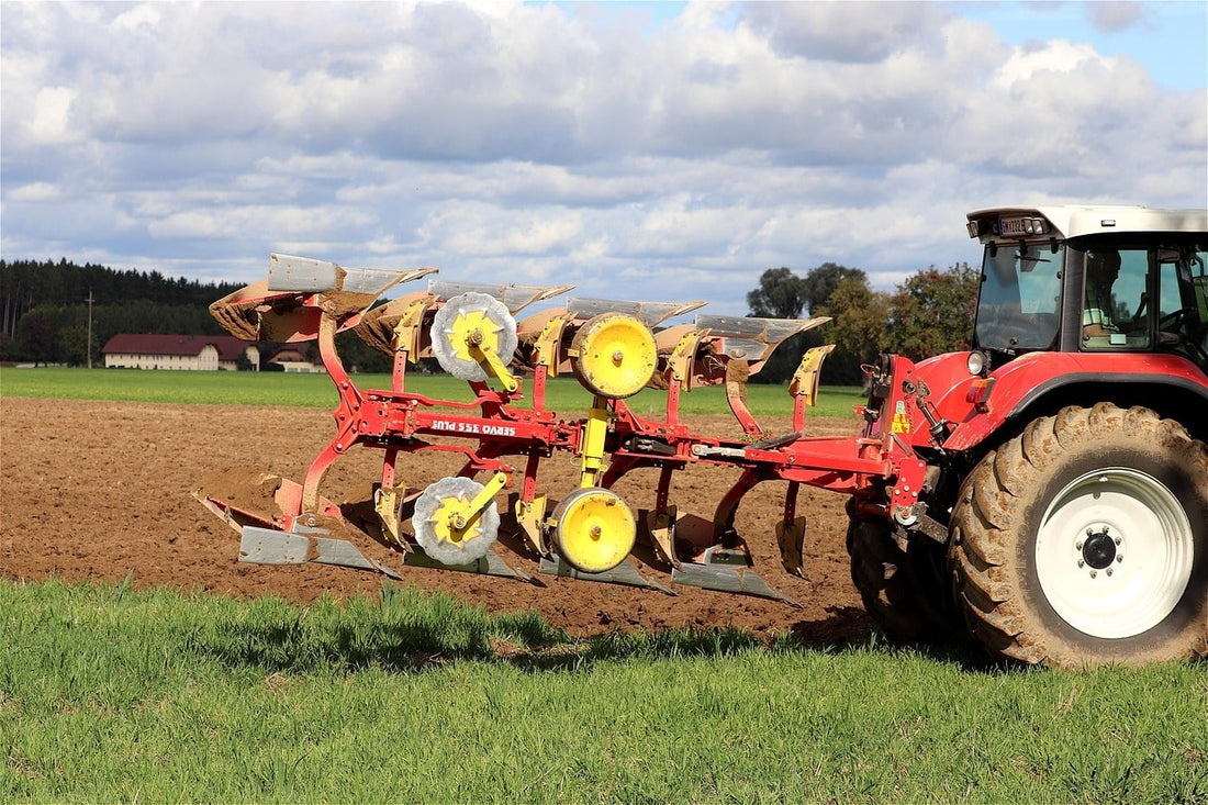 Outil agricole : charrue de labour rouge au champ